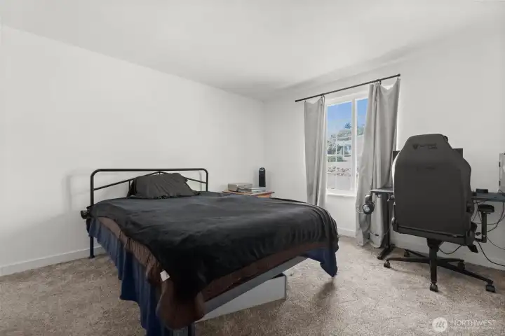 Retreat to the spacious primary bedroom — the largest in the home — with direct access just across the hall to the main-floor bath for everyday convenience.