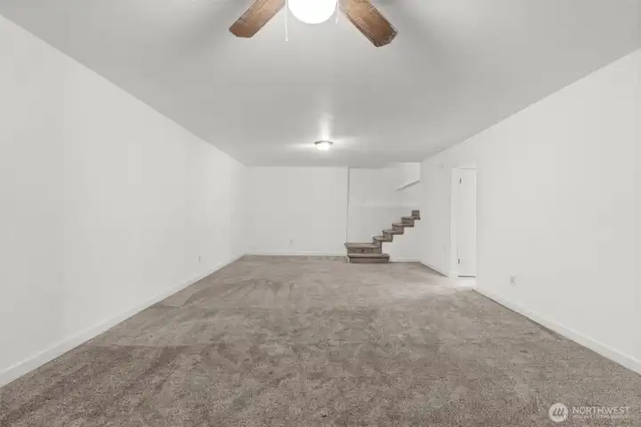Headed downstairs? Discover the ultimate gathering space — an expansive bonus room highlighted by a giant wood-burning fireplace insert, with plenty of room for a big-screen TV, couches, game table, or even a home gym.