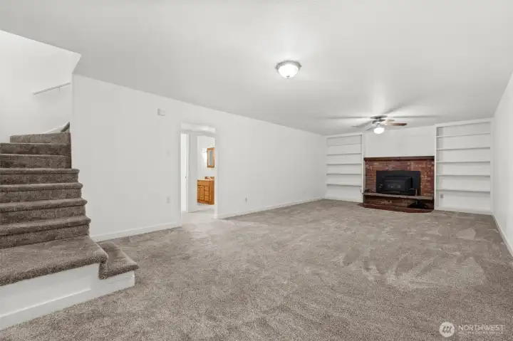 Headed downstairs? Discover the ultimate gathering space — an expansive bonus room highlighted by a giant wood-burning fireplace insert, with plenty of room for a big-screen TV, couches, game table, or even a home gym.