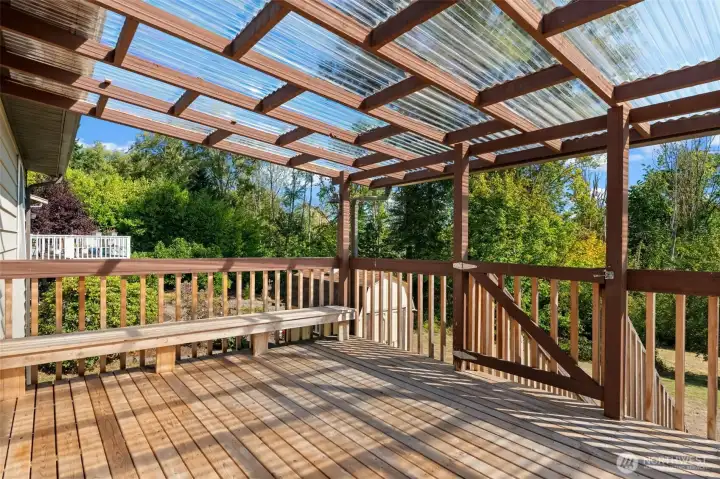 Step onto the covered backyard deck with sweeping views of the just shy of a half-acre yard — the perfect place to entertain guests rain or shine, and a true extension of the home’s living space.