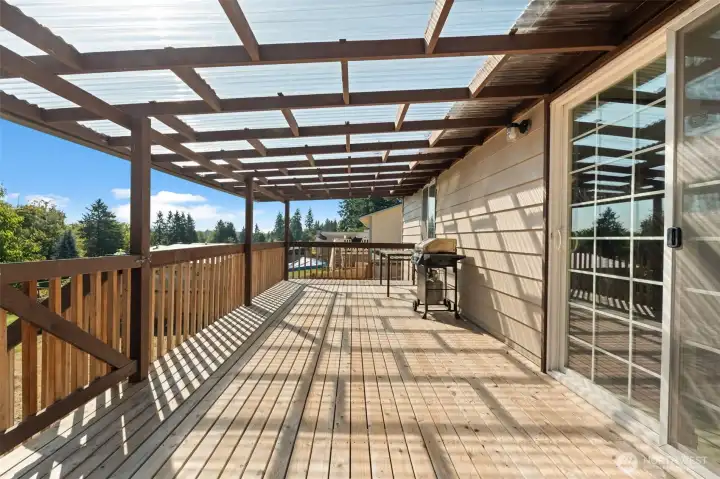 Step onto the covered backyard deck with sweeping views of the just shy of a half-acre yard — the perfect place to entertain guests rain or shine, and a true extension of the home’s living space.