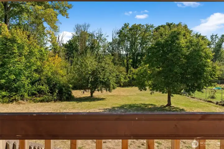 Step onto the covered backyard deck with sweeping views of the just shy of a half-acre yard — the perfect place to entertain guests rain or shine, and a true extension of the home’s living space.