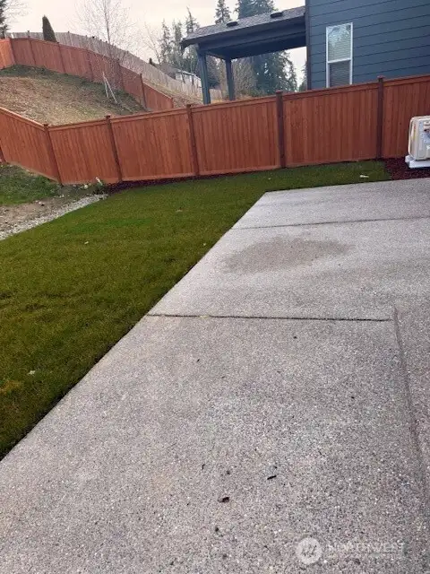 Fully fenced back yard with extended slab patio
