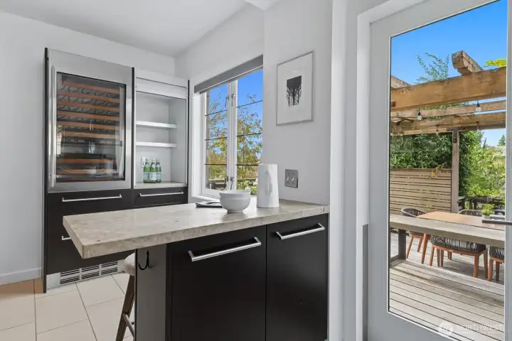 Accessing the Southwest facing deck from the kitchen is perfect for entertaining. Here is the beverage center and breakfast bar.