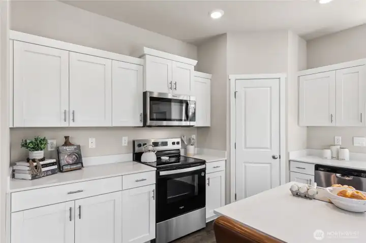 Modern shaker style cabinets and stainless-steel appliances. Actual home is under construction and finishes, colors, and materials may vary. See site agent for details.