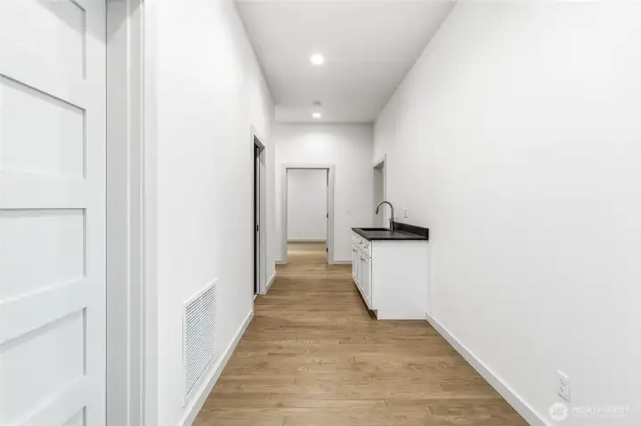 Hall entry off of garage with utility counter & sink. Perfect area for an additional fridge/freezer, mudroom/drop space. Hall entry off of garage with utility counter & sink. Perfect area for an additional fridge/freezer, mudroom/drop space.