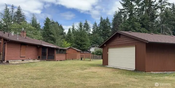 Back view of home Enclosed Porch Detached Garage Fenced Play Area