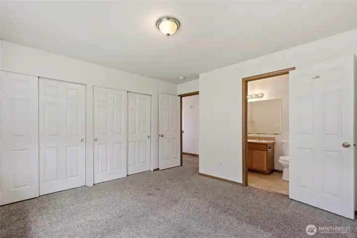 Primary bedroom leading to private bath and hallway. Dble closets
