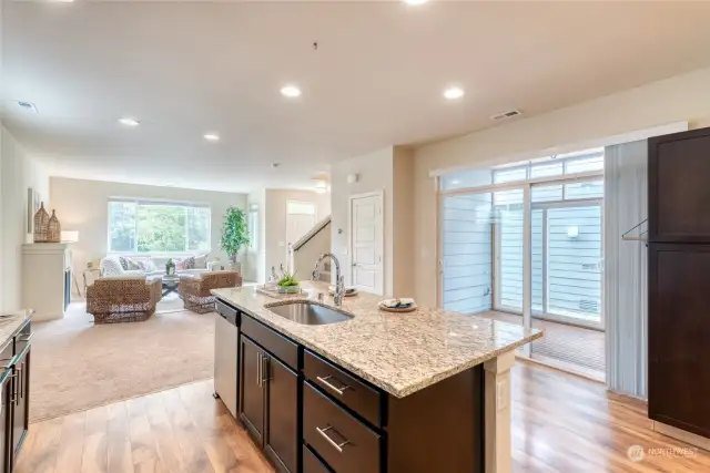 The gourmet kitchen looks out to the living and dining spaces in an open easy flow functional floor-plan.