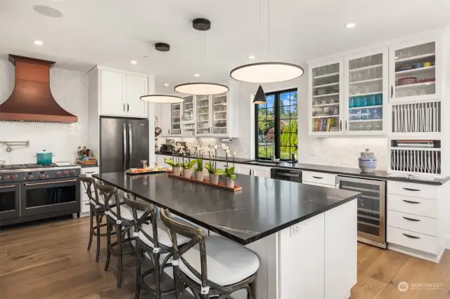 A chef's dream kitchen featuring stunning soapstone countertops and high-end designer lighting illuminating the spacious eating bar.