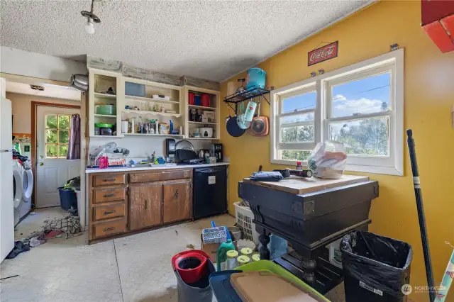 Kitchen from living room with utility room in background