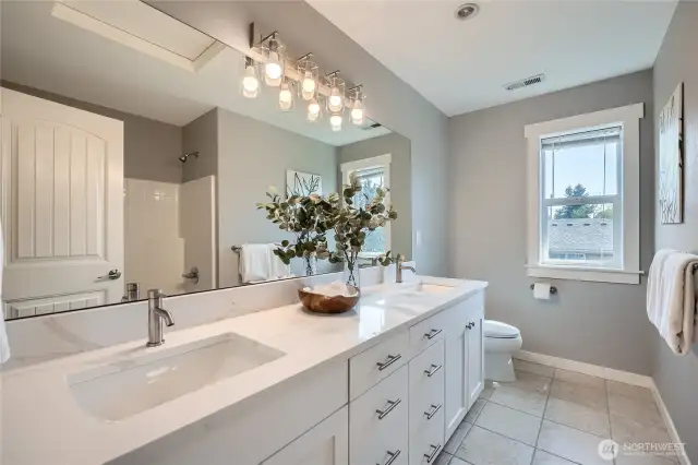 This upper-level full bathroom boasts stylish new quartz countertops and modern lighting fixtures, creating a fresh and elegant space that combines functionality with contemporary design.