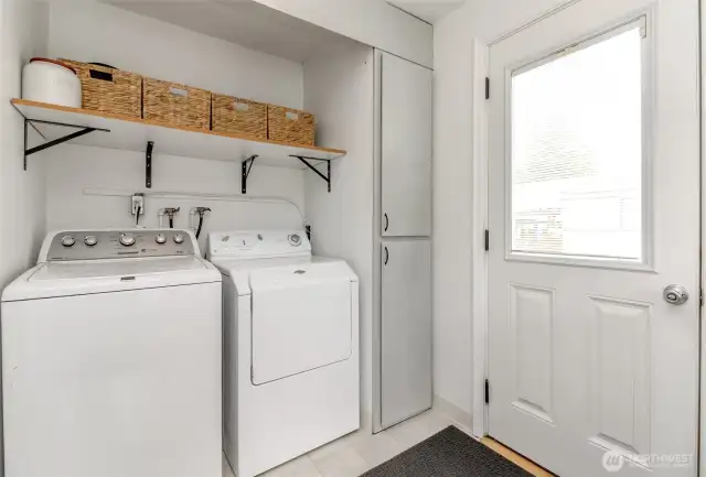 Laundry with extra storage cabinets and shelving