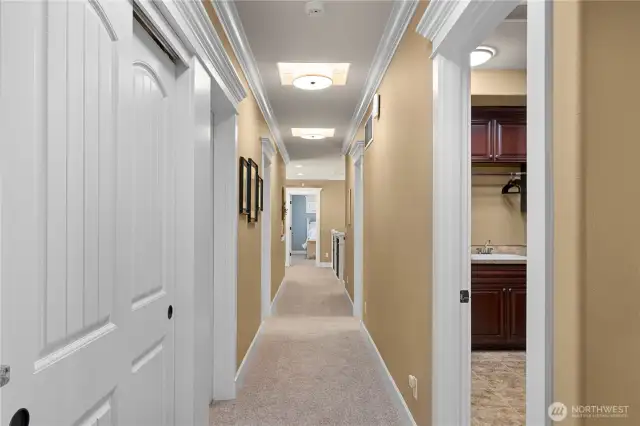 Hallway leading to other bedrooms, bathrooms, bonus room & theater room.  Utility room on right.