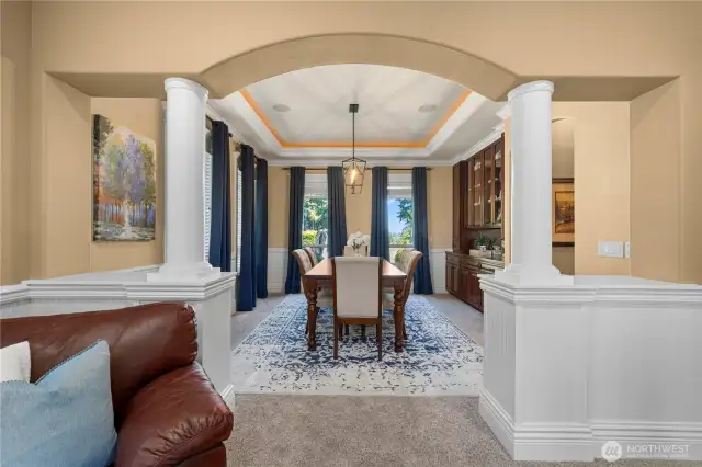 Columns & wainscoting lead into the formal dining w/built-ins, surround sound, coffered ceiling w/double crown molding & accent lighting.  New drop down light fixture.