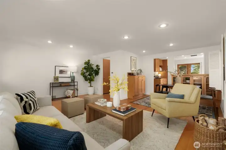 A view standing by the fireplace looking to dining and kitchen.