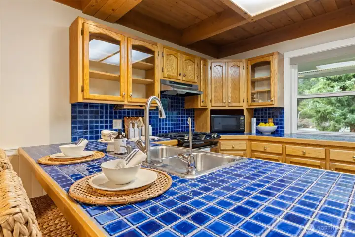 Kitchen with generous counter space, warm wood finishes, and the added convenience of an instant hot water dispenser at the sink.