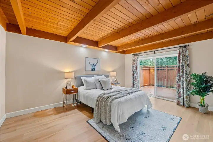 Main-level bedroom with beautiful wood ceilings and direct access to a private deck, creating a quiet retreat within the home.