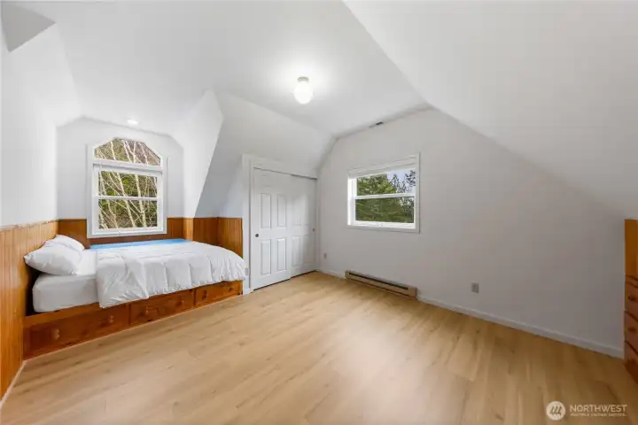 Upper-level bedroom featuring a custom built-in bed with drawers for extra storage, a spacious closet, and additional built-in drawer space along the walls, making the most of every inch.