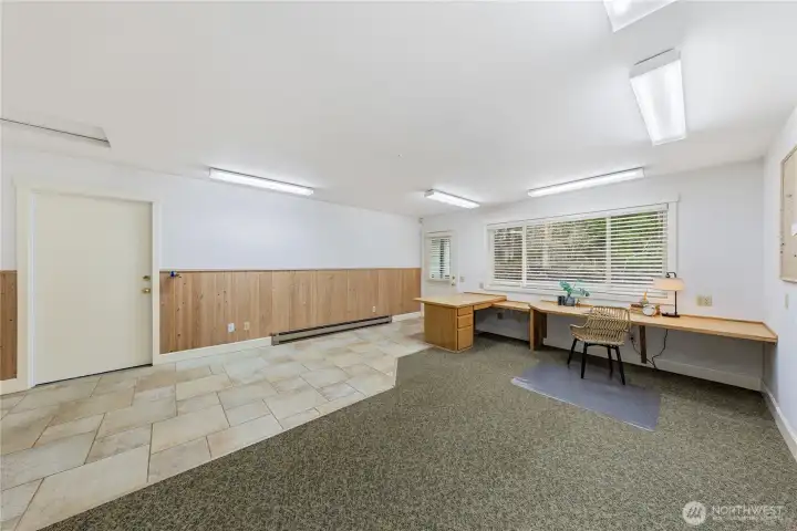 A closer look highlights the thoughtful flooring design, with durable earthy tone tile in the high traffic area for easy maintenance, transitioning into low pile carpet for a softer, quieter workspace.