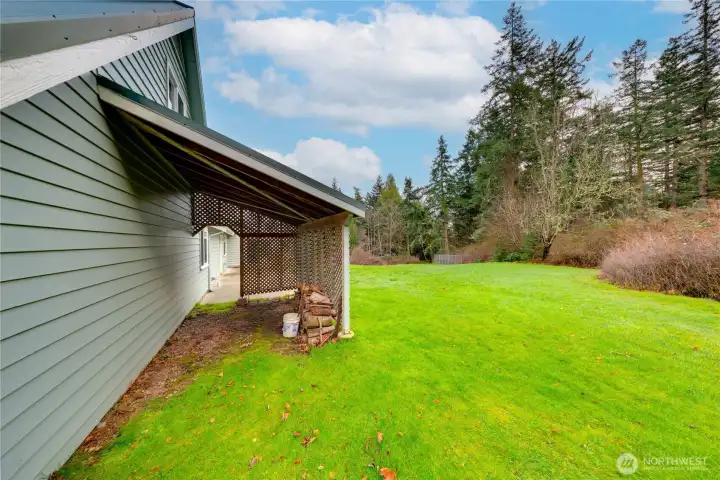 Covered area in the backyard, perfect for storing firewood for the fireplace or lawn and garden equipment.