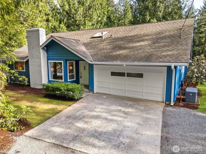 Practical features have also been thoughtfully considered throughout the property. A wood storage area along the side of the home ensures easy access for the wood-burning fireplace, blending functionality with the home’s overall design.