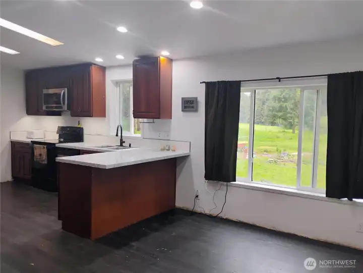 Bright dining space with large window overlooking the backyard
