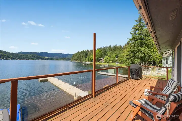Expansive lakefront deck with glass railing, seating space, and direct views across Summit Lake. Expansive lakefront deck with glass railing, seating space, and direct views across Summit Lake.