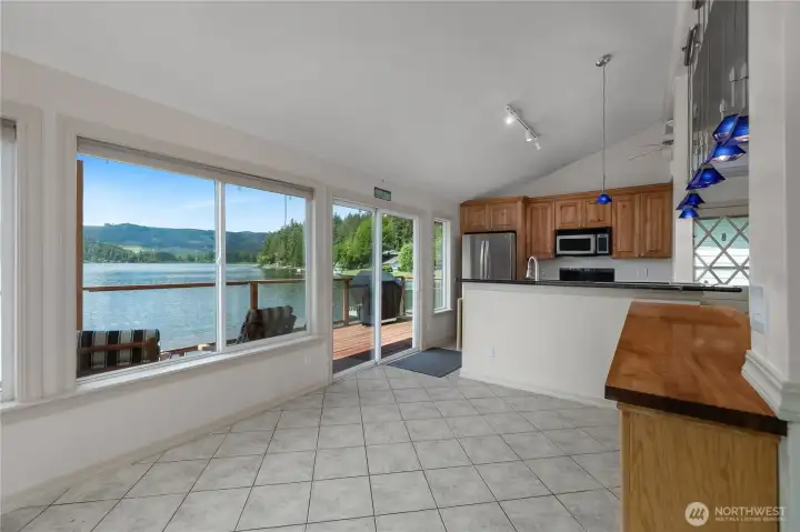 Kitchen and dining area enjoy lake views, deck access, maple cabinetry, and easy-care tile flooring. Kitchen and dining area enjoy lake views, deck access, maple cabinetry, and easy-care tile flooring.