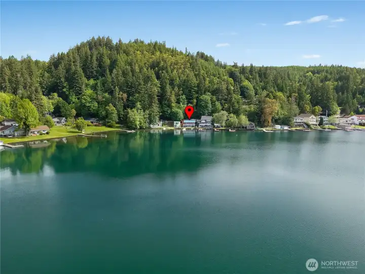 Aerial view highlights the home’s location on Summit Lake with forested hills and waterfront setting. Aerial view highlights the home’s location on Summit Lake with forested hills and waterfront setting.