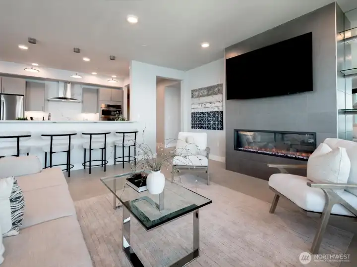 The open-concept living room is anchored by a sleek linear electric fireplace. Your TV, shown here, is included. The open-concept living room is anchored by a sleek linear electric fireplace. Your TV, shown here, is included.