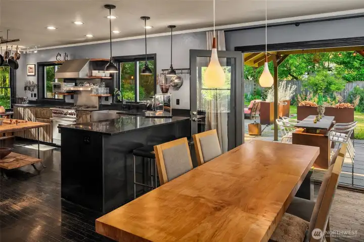 The dining room serves as a natural gathering place, connecting indoor entertaining with the patio and gardens beyond.