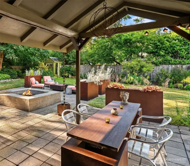 French doors open to a covered patio and thoughtfully designed outdoor gathering spaces surrounded by lush gardens.