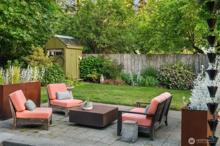 Thoughtfully designed hardscaping, mature gardens, and inviting seating areas create a backyard meant for year-round enjoyment.