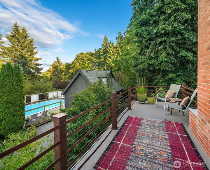 A private deck extends the primary suite outdoors, offering a peaceful perch above the gardens and pool.
