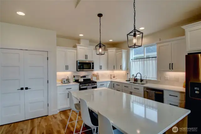 Large pantry, custom cabinetry, and large island with seating