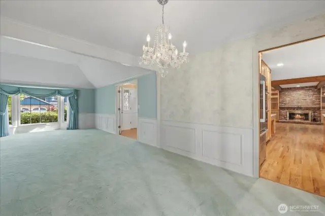 Another view of the living room looking towards the front entryway, and a peak at the kitchen and family room.