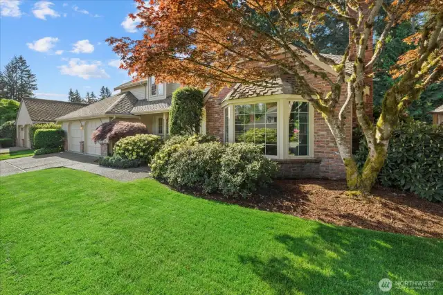 This view of the front yard shows off the beautiful mature landscaping.