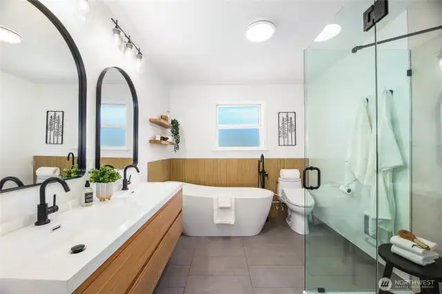 The remodeled spa-inspired primary bathroom with double sinks and soaking tub