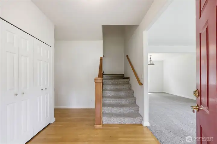 Inside entrance is a large coat closet, stairs leading upstairs and to the right a formal living area leading into the dining room.