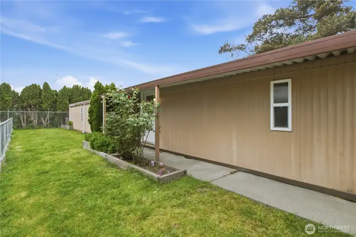Covered walkway to front entry, front yard is fenced ~