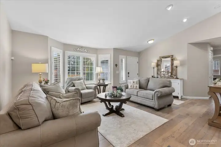 Spacious living area w/ bay window, neutral tones, & seamless flow into the main living spaces.