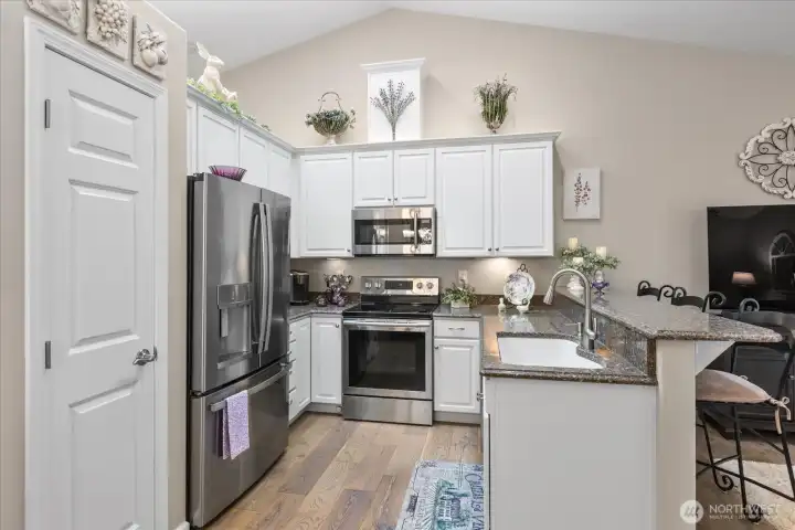 Functional kitchen layout w/ abundant cabinetry, generous prep space, & updated finishes throughout.