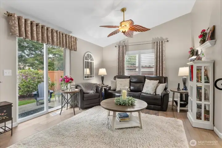 Inviting family room w/ vaulted ceilings, expansive windows, & direct access to the patio & backyard.
