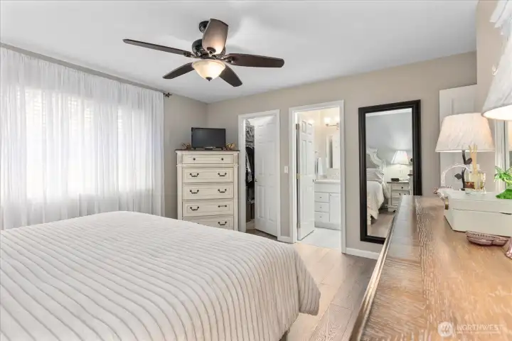 Bright & inviting primary bedroom offers comfort, functionality, & seamless access to the private bath.