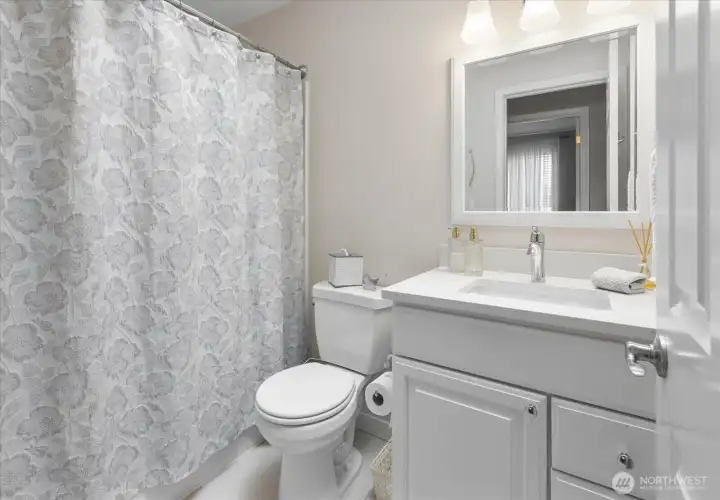 Bright & refreshed main bathroom features updated vanity, modern fixtures, & clean finishes.