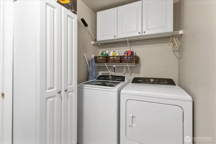 Convenient laundry area with built-in storage cabinets to help keep everyday essentials organized.