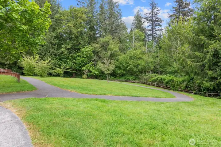 Peaceful neighborhood walking paths wind through lush green space, creating the perfect setting for morning walks or evening strolls.