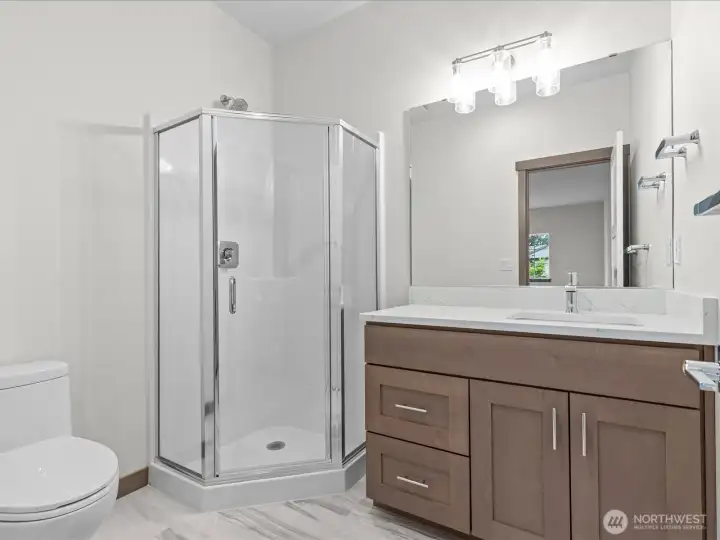 Modern upper-level 3/4 bathroom complete with a freestanding glass shower, contemporary fixtures, and direct access from the bedroom.