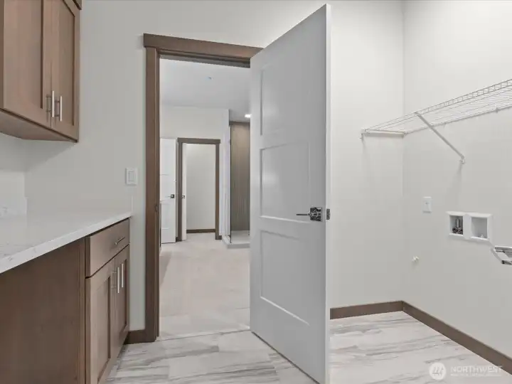 Highly functional upper-level utility room situated close to the bedrooms, featuring a built-in wash sink and excellent storage space.